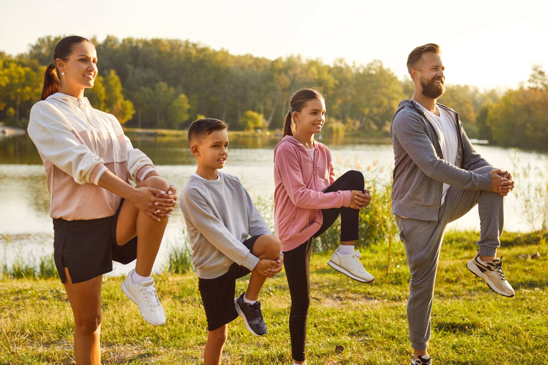 Familj som tränar tillsammans utomhus vid en sjö